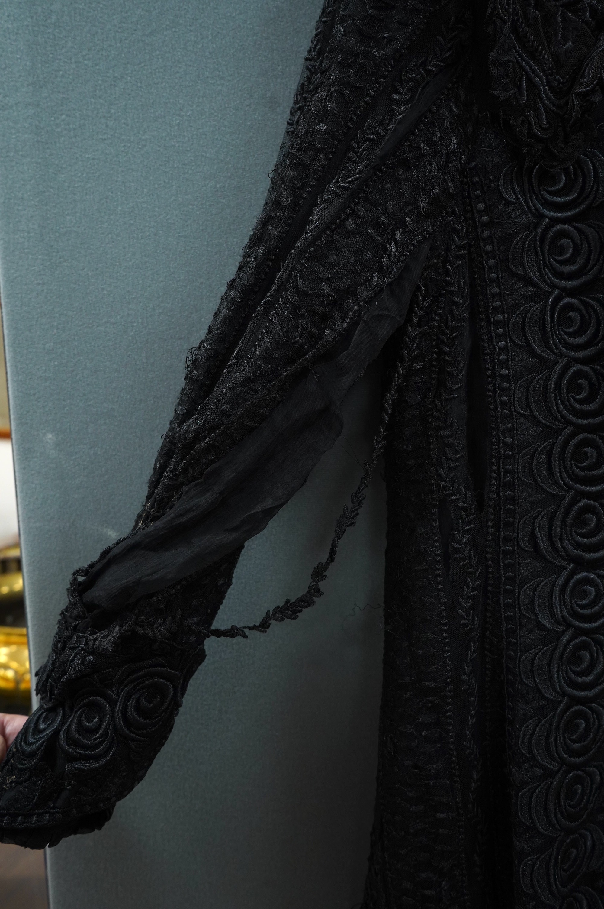 An Edwardian black chiffon and lace evening jacket with tassel decoration to the front and back, edged with tasselled fringing to the edge of sleeves and bottom, 85cm long from nape of neck at the back to bottom of tasse